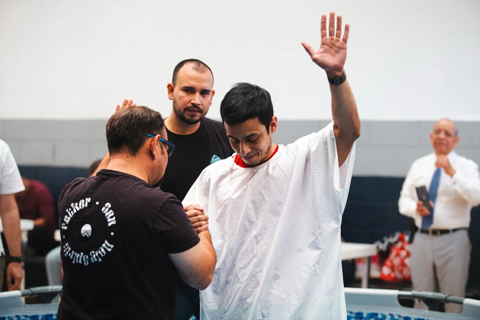 Persona levantando la mano durante un bautismo en la iglesia